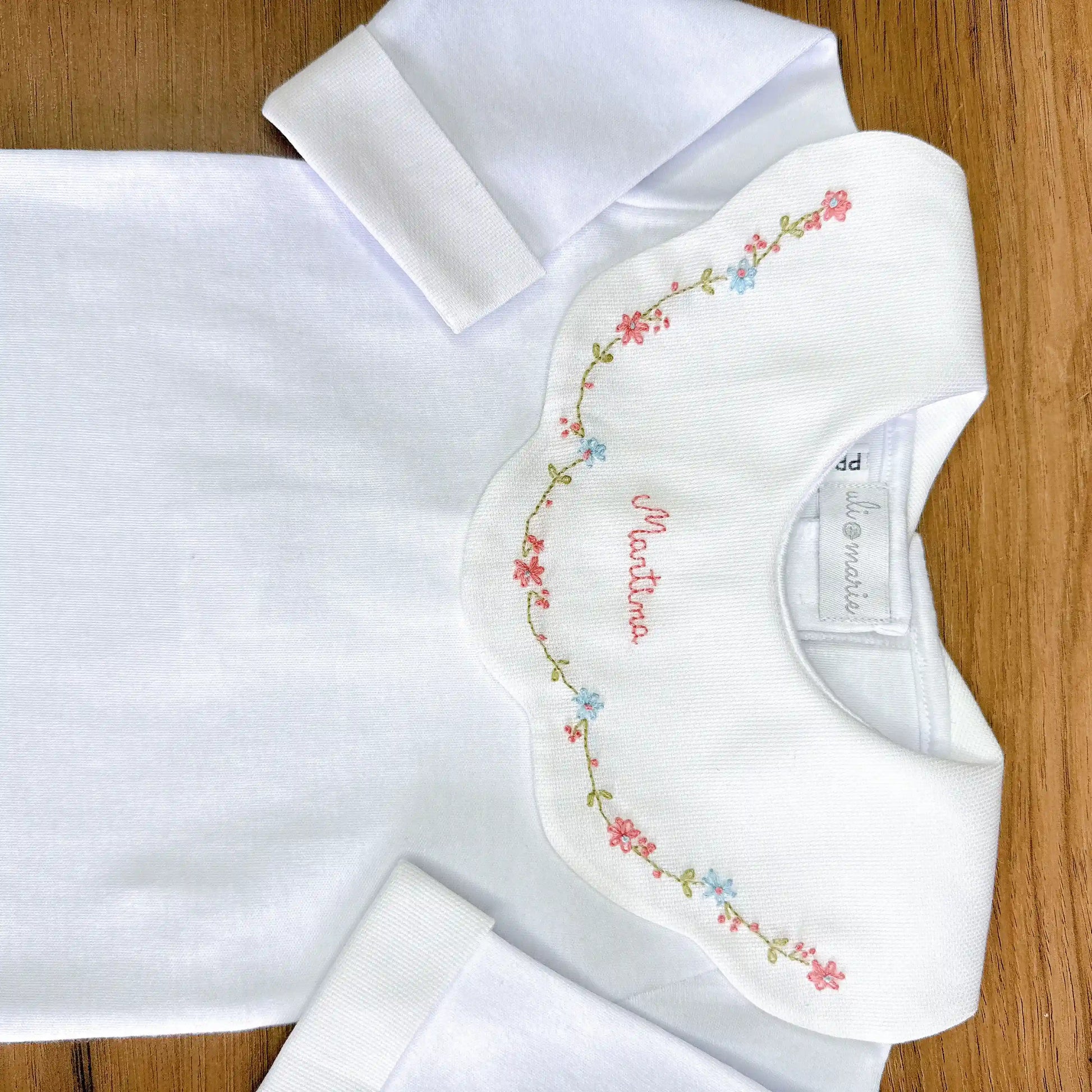 body encanto rosa e azul branco com gola bordada em flores rosa e azul e nome martina bordado
