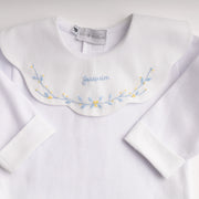 Body infantil branco manga longa com gola canelada e bordado folhagens azul e amarelo