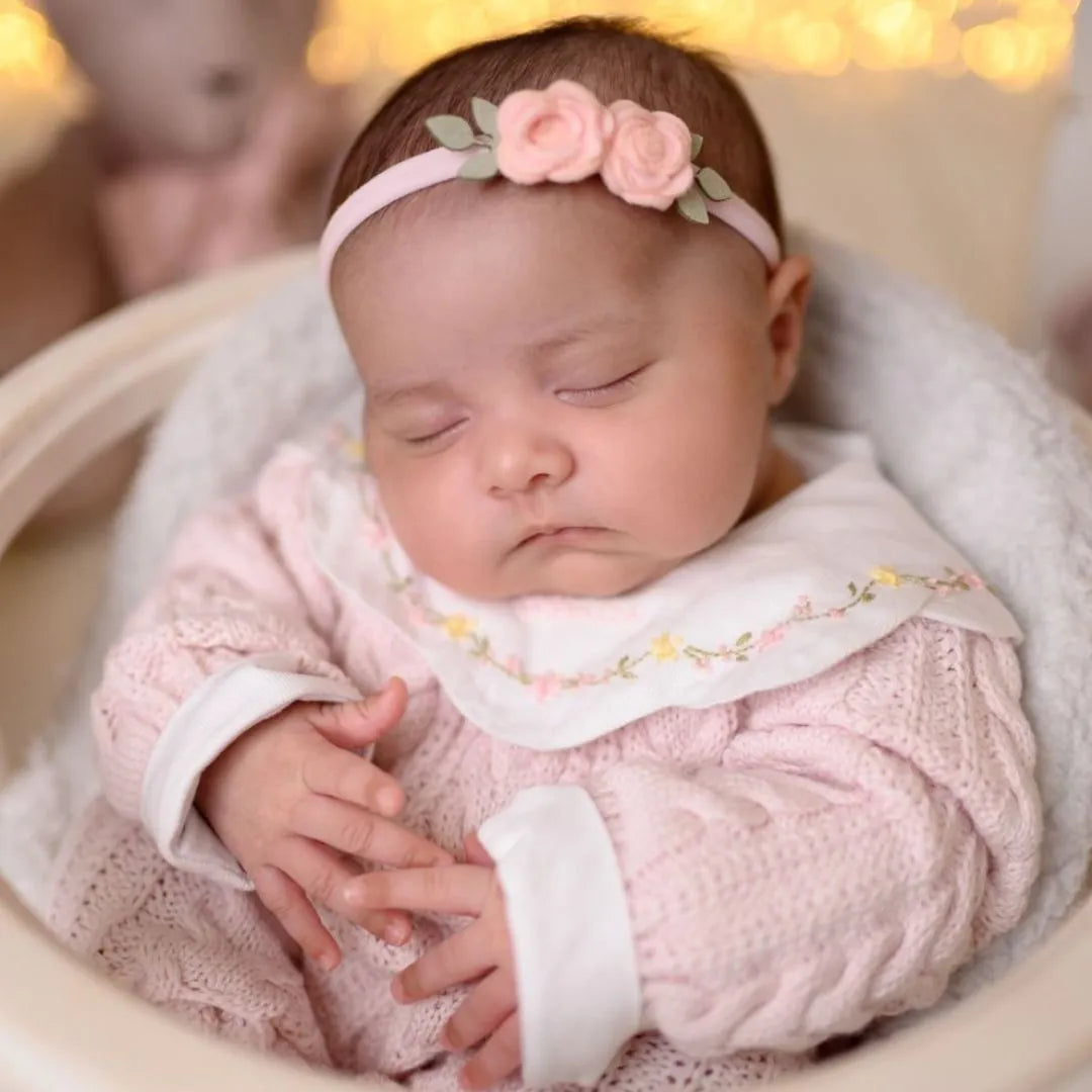 Saída Maternidade Celina em tricô rosa claro com body branco bordado com flores delicadas na gola