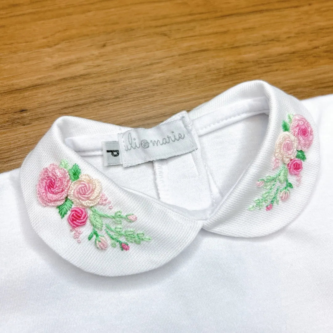 body amor perfeito branco com gola bordada de rosas cor de rosa e punho monogramado com inicial mv e laço