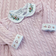 body delicatto branco de manga longa com punhos dobrados, e gola redonda bordada com flores em tons pastel