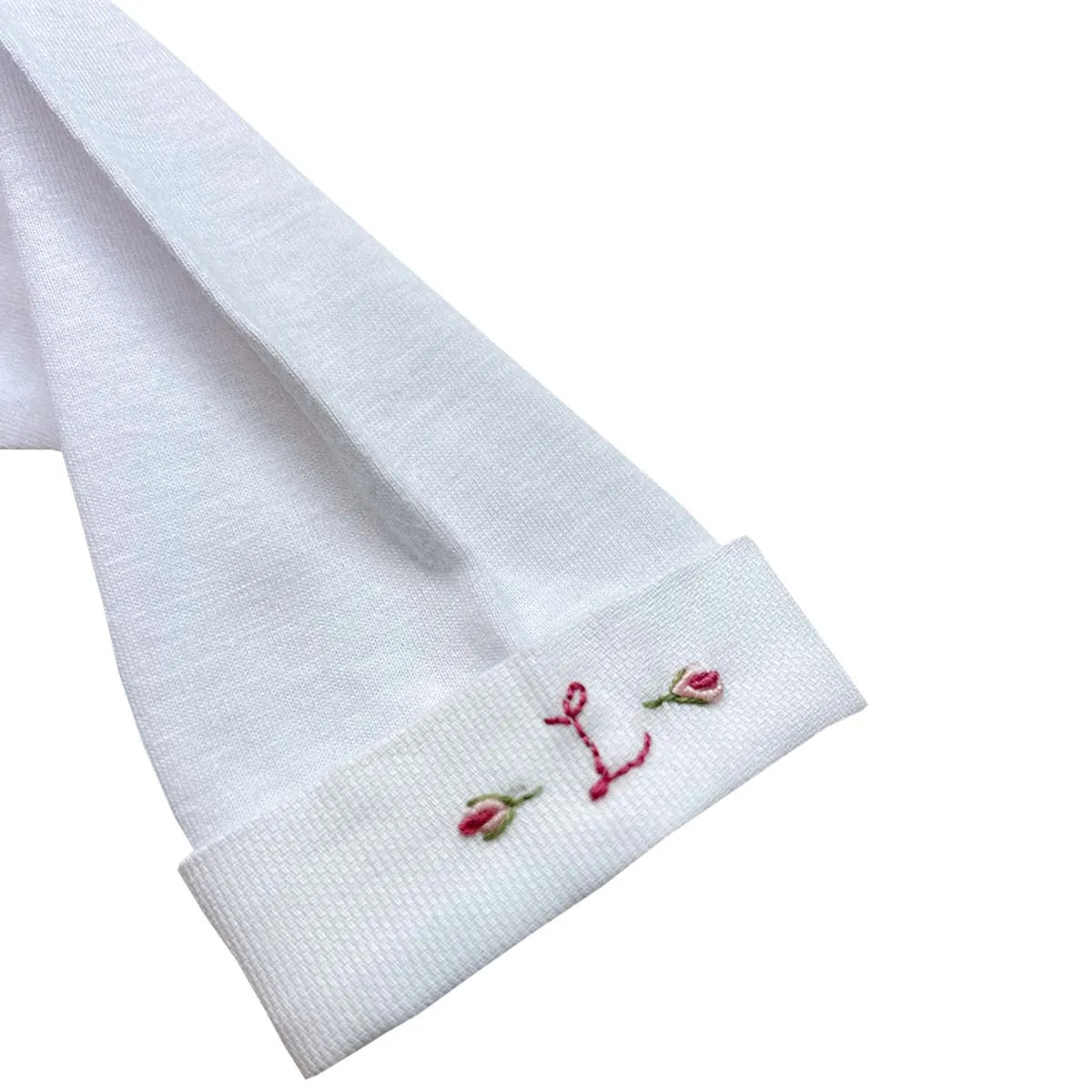 body delicatto branco de manga longa com punhos dobrados, e gola redonda bordada com flores em tons pastel