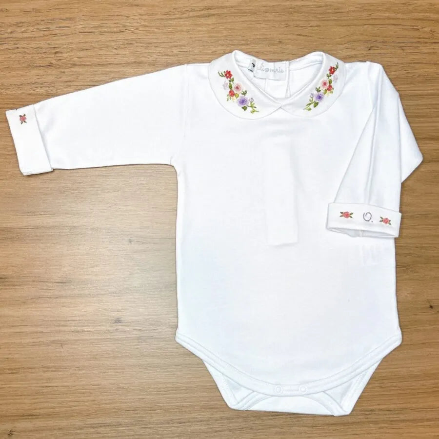 body lilac, modelo branco com gola bordada em flores coloridas nos tons de lilás, rosa e verde, confeccionado em algodão macio para o máximo conforto do bebê