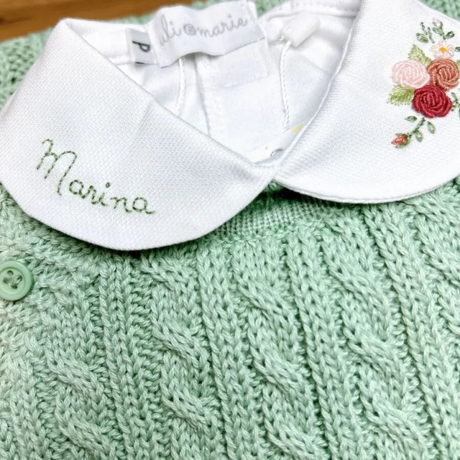 body marina em tricô verde-água com gola branca bordada, detalhes florais e nome "marina" delicadamente costurado