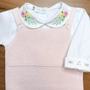 body martina branco em malha de algodão com gola redonda bordada com flores coloridas, sobre fundo de madeira