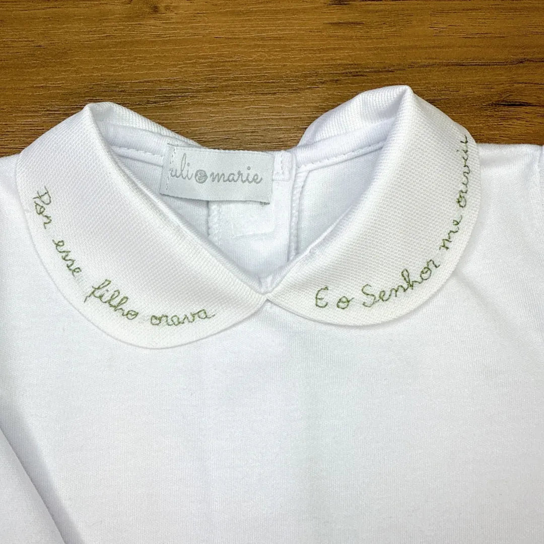 body milagre branco com gola peter pan bordada em vermelho com frase religiosa e detalhe de botão vermelho no punho