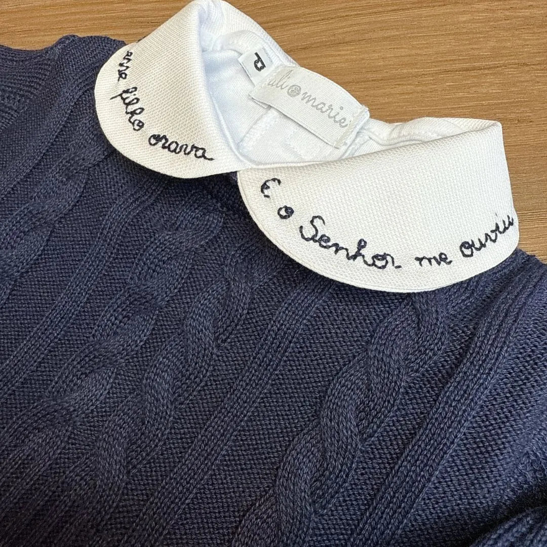 body milagre branco com gola peter pan bordada em vermelho com frase religiosa e detalhe de botão vermelho no punho
