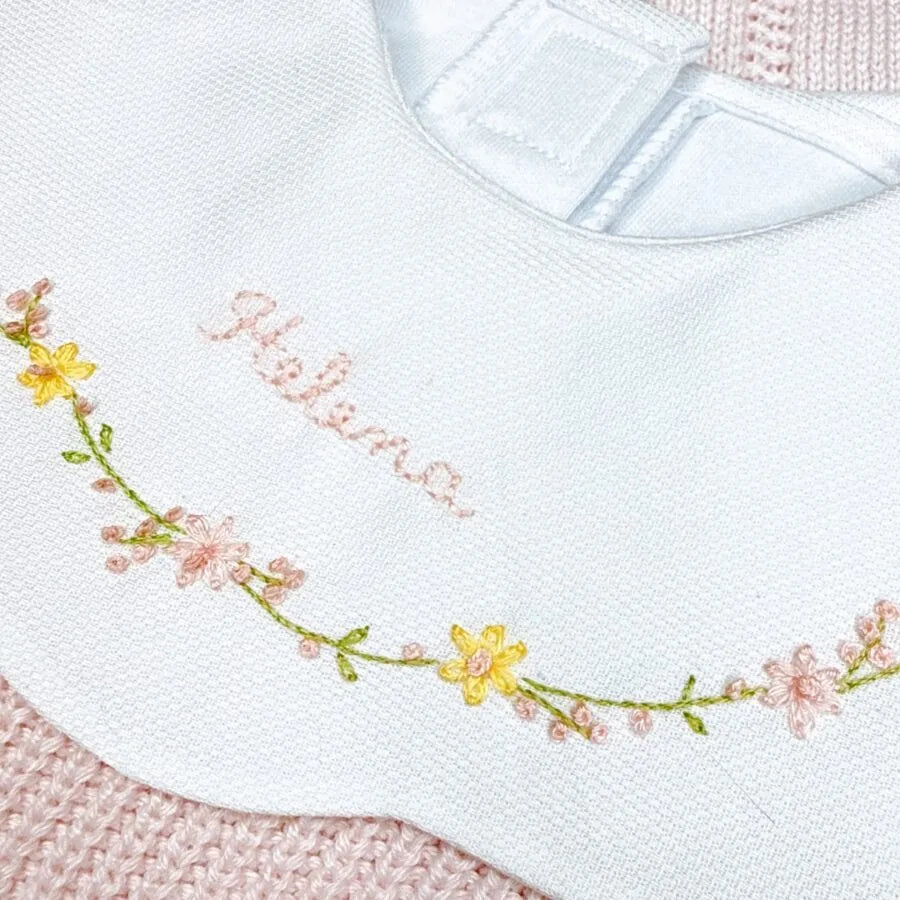 detalhe do body encanto amarelo bebê com gola peter pan bordada com flores e nome helena no centro