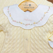 detalhe do body encanto amarelo bebê com gola peter pan bordada com flores e nome helena no centro