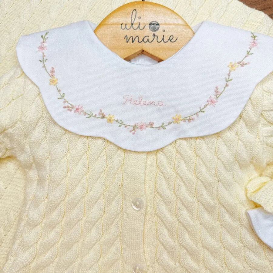 detalhe do body encanto amarelo bebê com gola peter pan bordada com flores e nome helena no centro