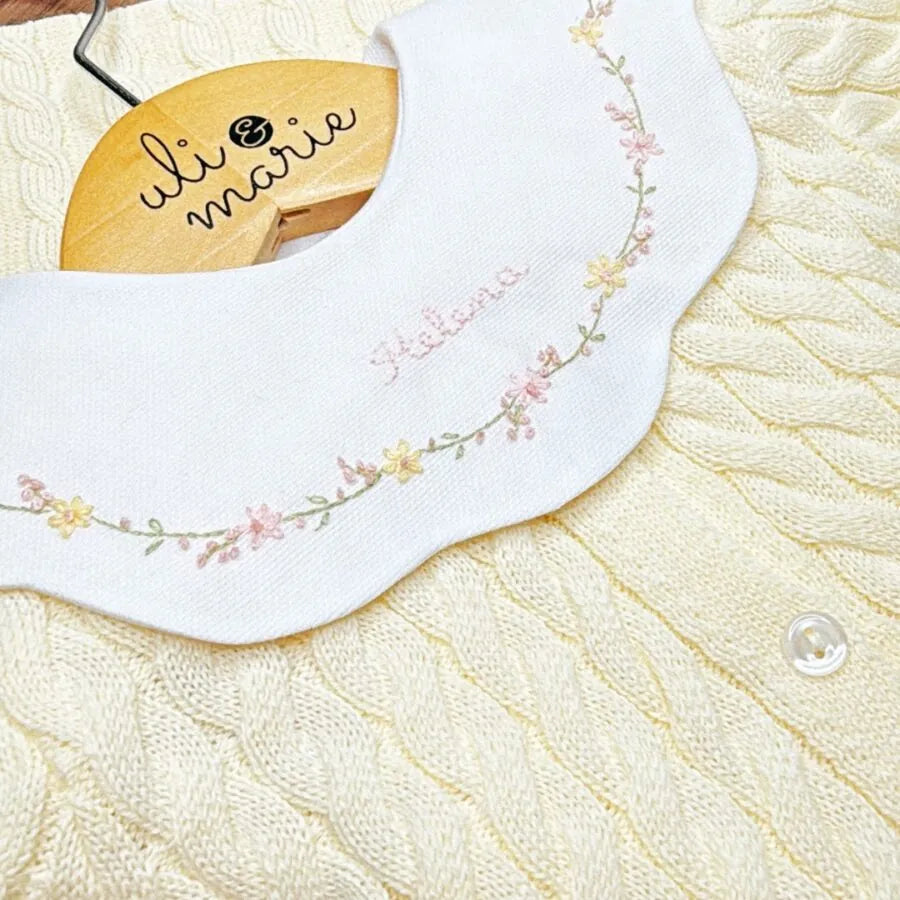 detalhe do body encanto amarelo bebê com gola peter pan bordada com flores e nome helena no centro