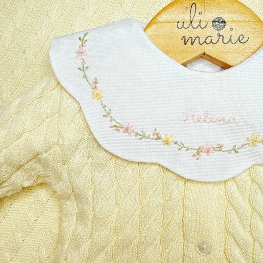detalhe do body encanto amarelo bebê com gola peter pan bordada com flores e nome helena no centro