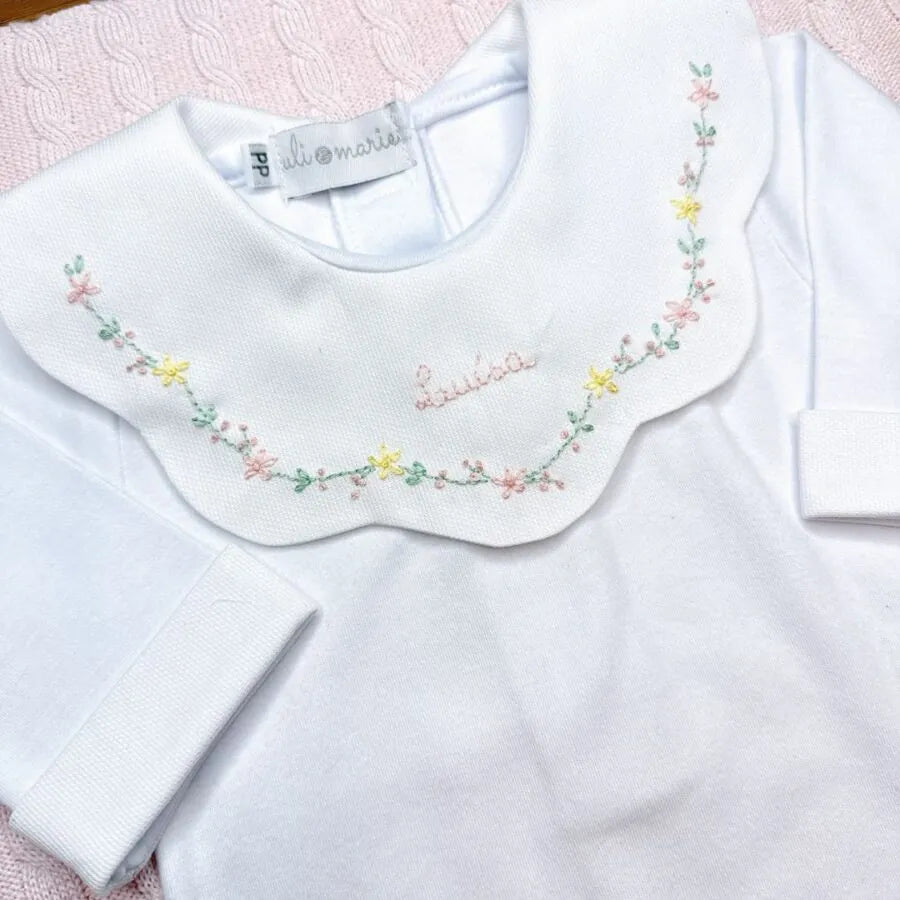 detalhe do body encanto amarelo bebê com gola peter pan bordada com flores e nome helena no centro