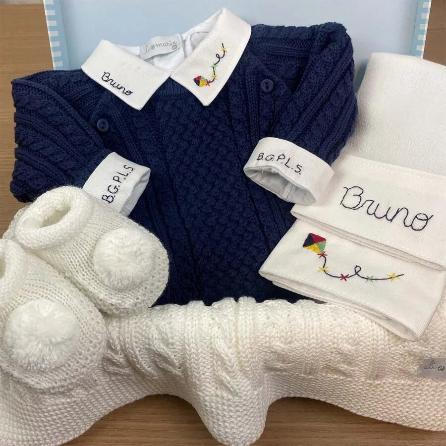 detalhe do body de tricô azul marinho com gola branca bordada com nome e foguete e punho monogramado