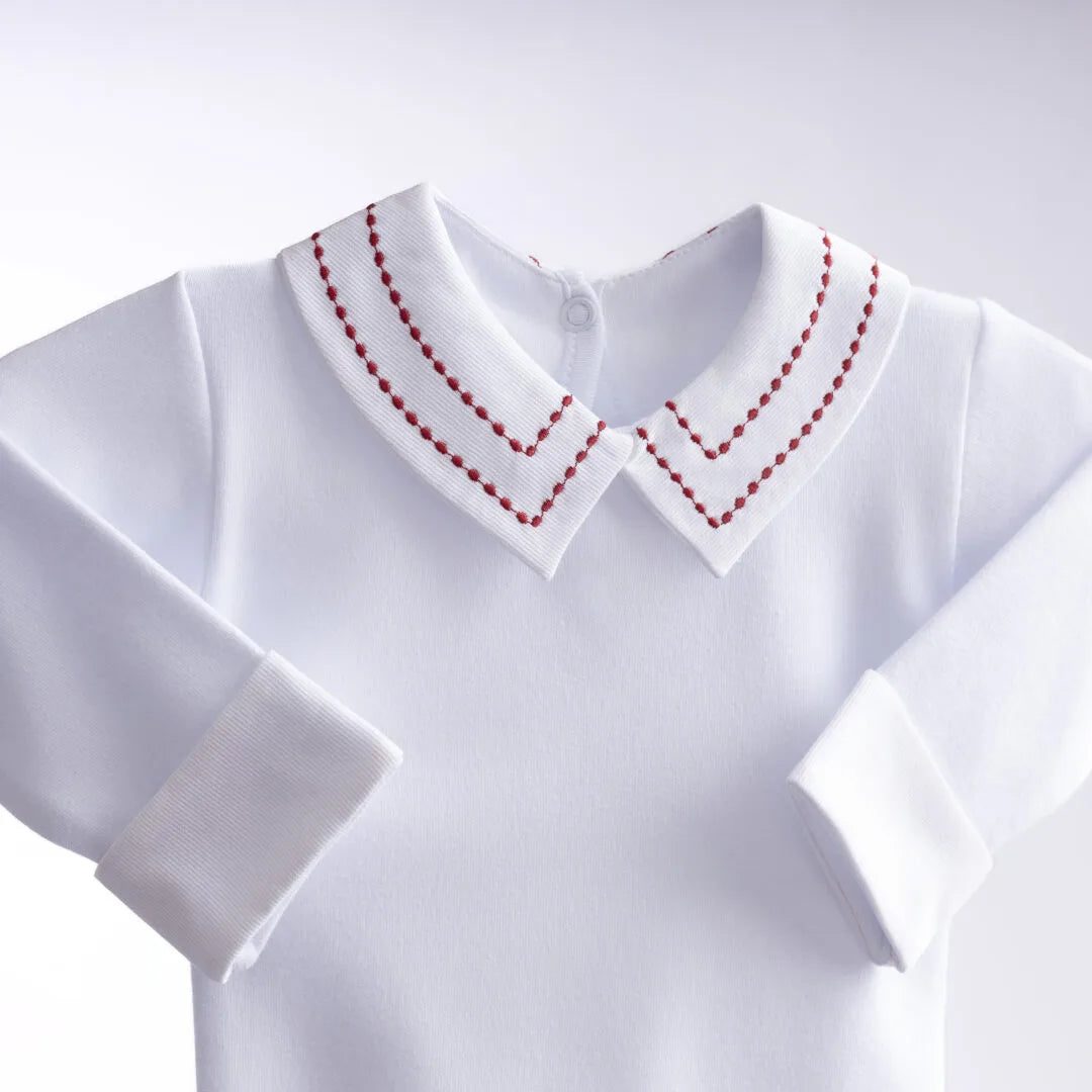 body pontilhado vermelho branco com gola dupla bordada em pespontos delicados, mangas longas com punhos e fechamento por botões