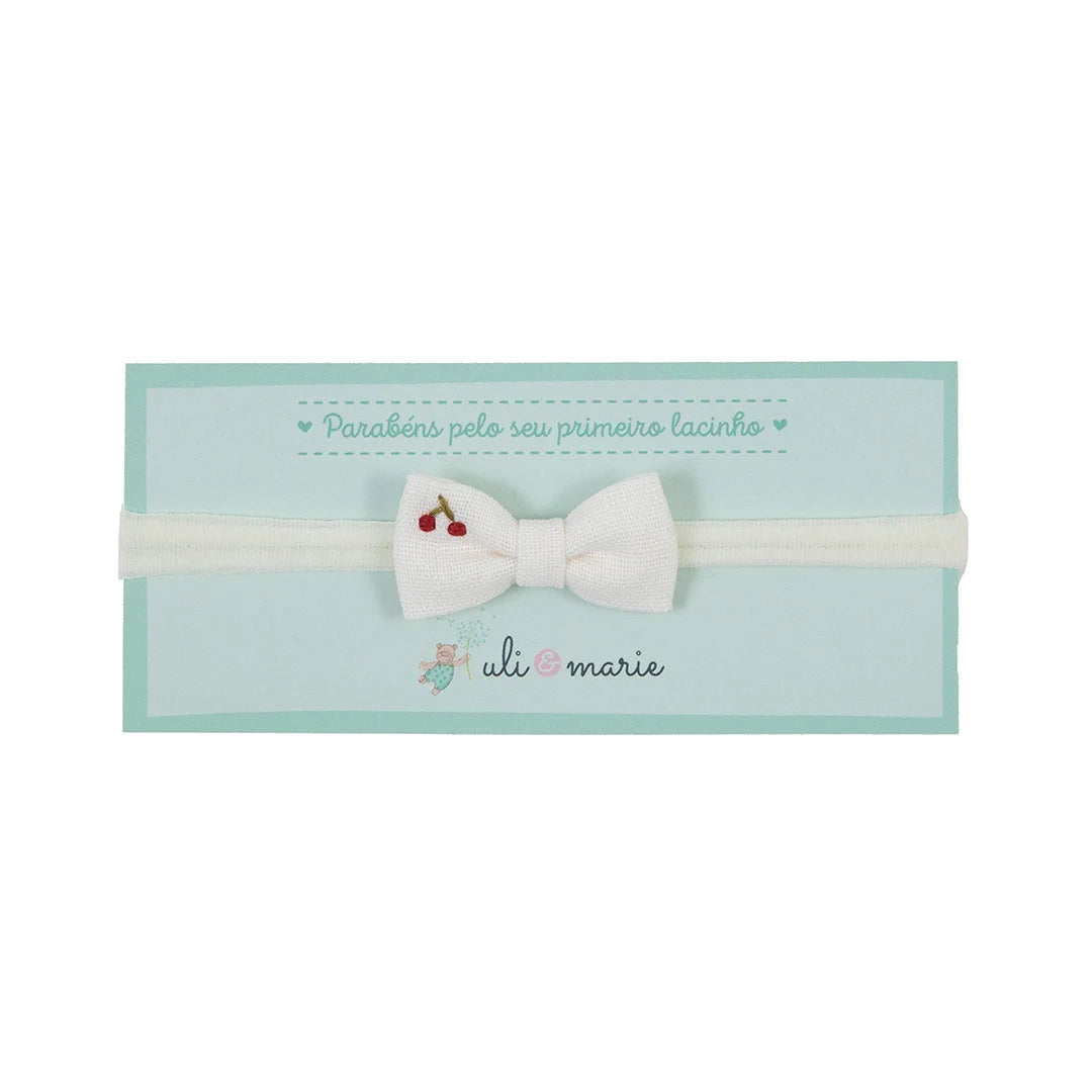 faixa de cabelo cereja offwhite com laço de tecido claro bordado com cerejinhas vermelhas sobre elástico suave