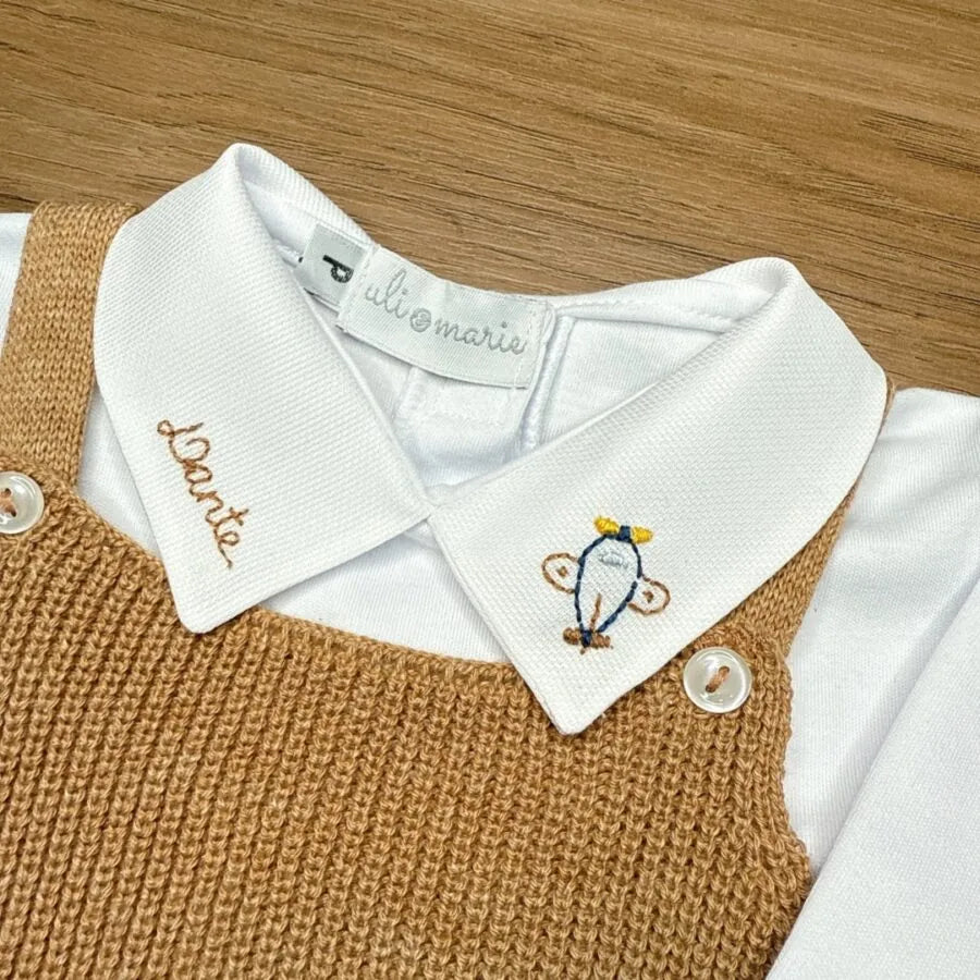 jardineira bambu caramelo em tricô vista de cima, sobre body branco de manga longa com gola bordada aviãozinho