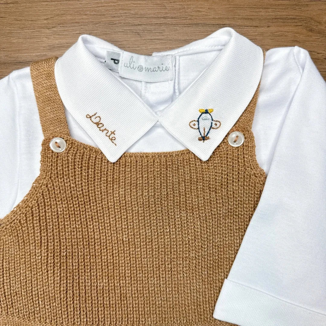 jardineira bambu caramelo em tricô vista de cima, sobre body branco de manga longa com gola bordada aviãozinho