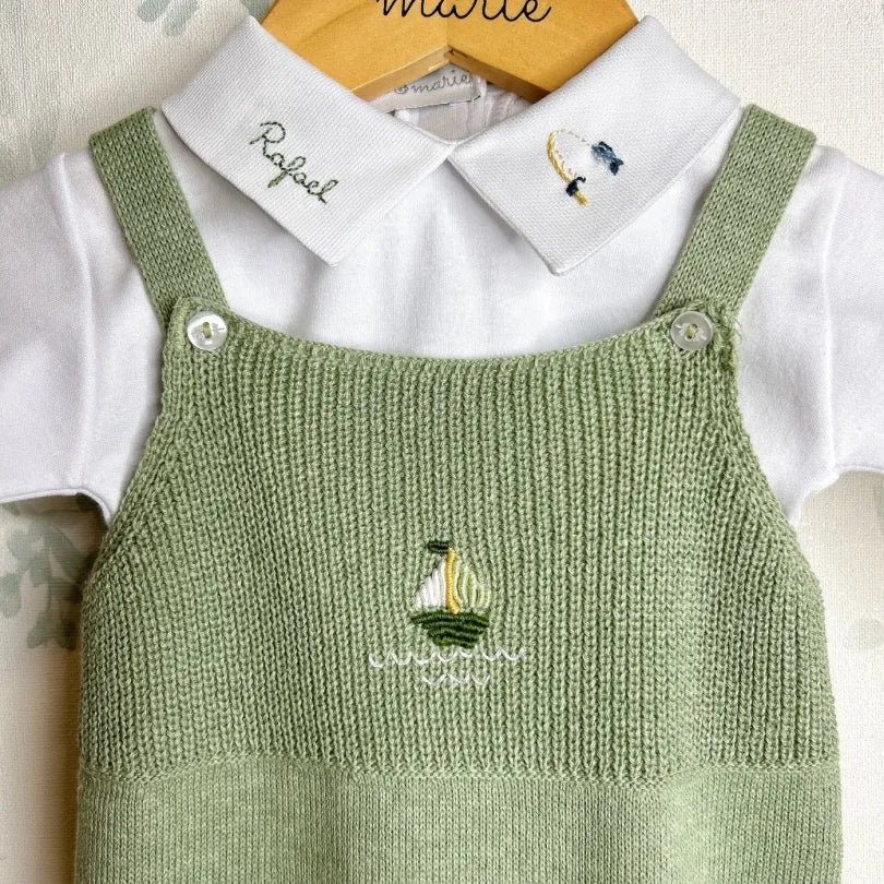 jardineira pescador em tricô sobre body branco manga longa, com bordado de barquinho e nome personalizado