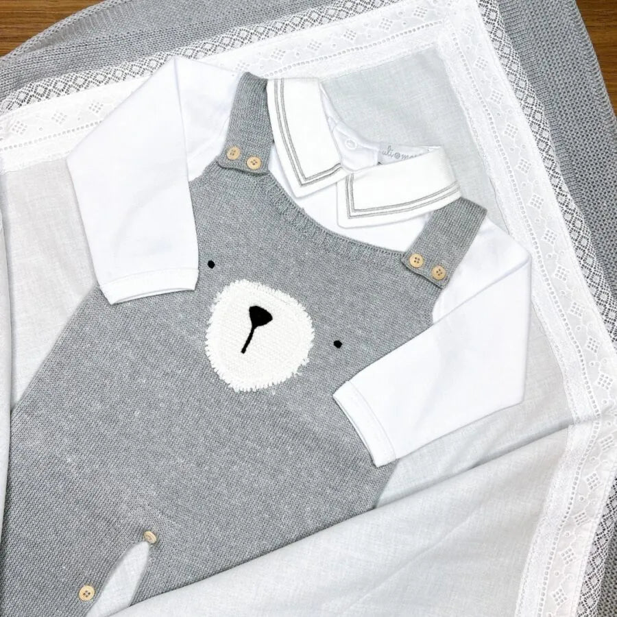 jardineira teddy cinza de tricô com body branco de manga longa, detalhe de rosto de urso bordado no peito