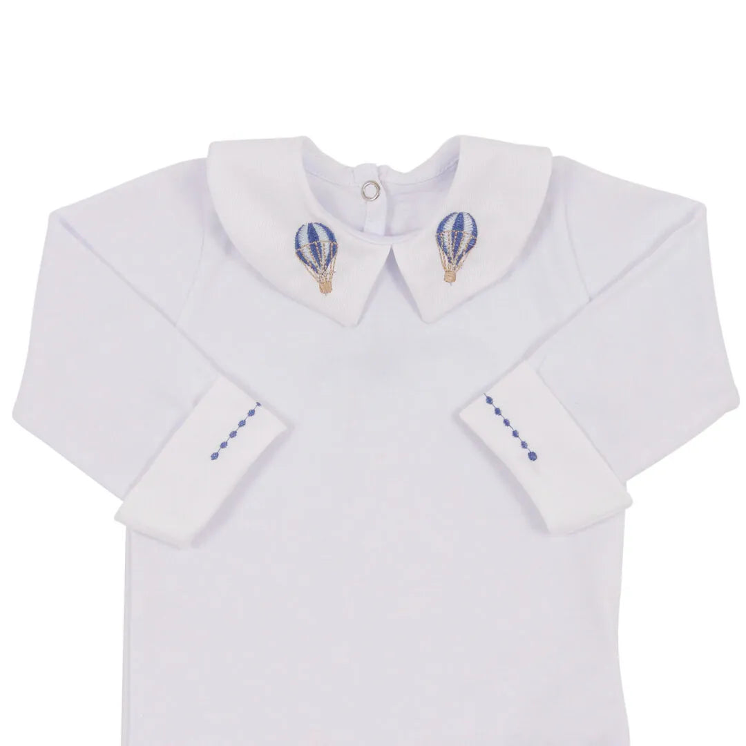 close-up do body branco de manga longa com gola bordada de balões e punhos virados com costura em azul