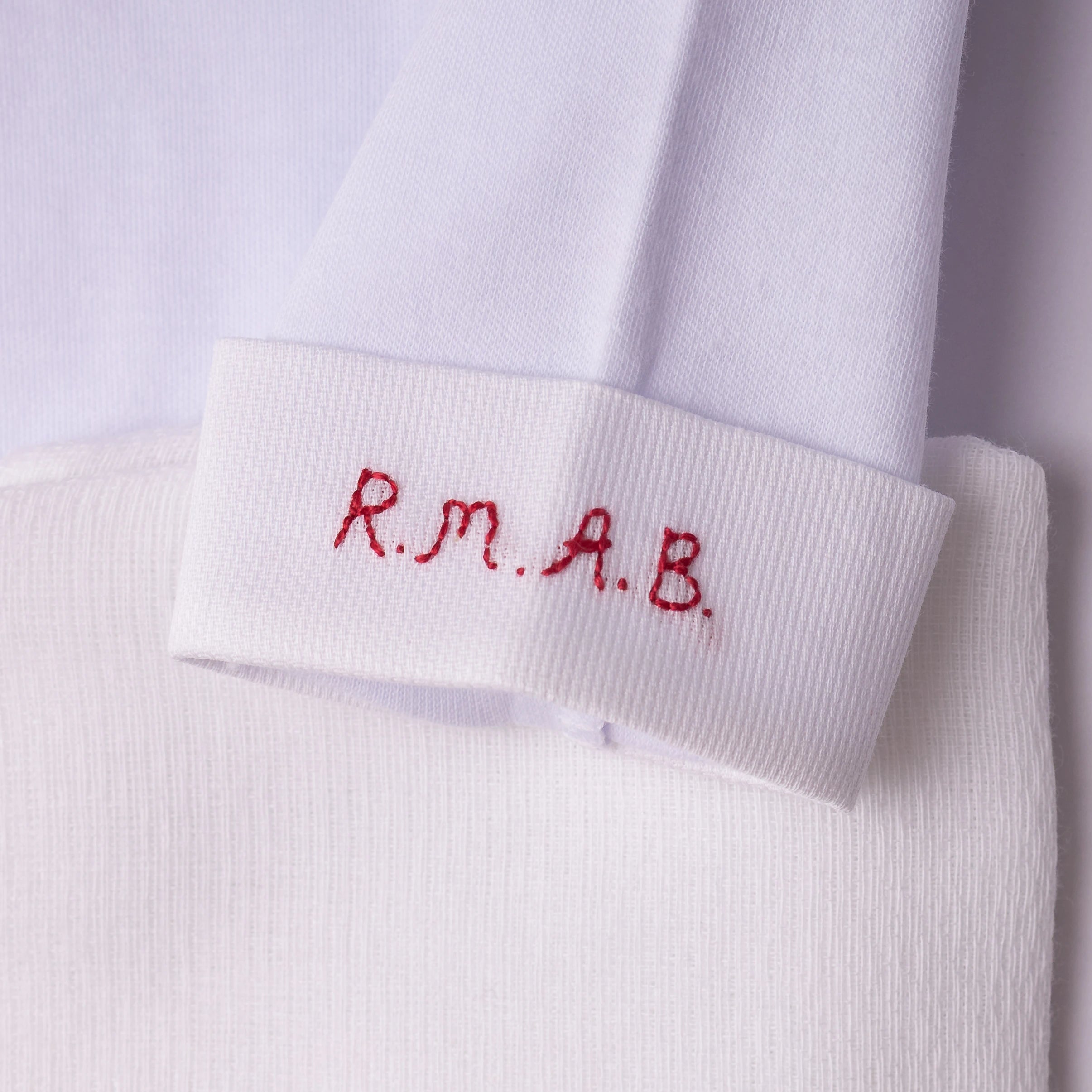 Punho de calça branco com bordado R.M.A.B e cavalo colorido