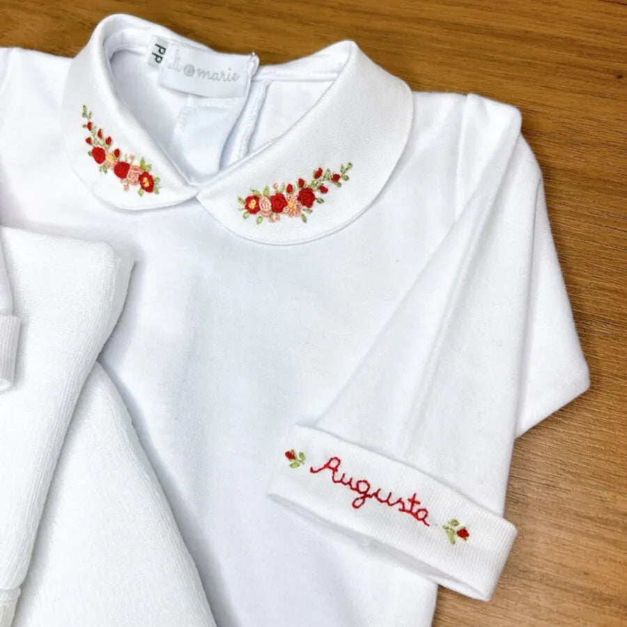 kit maria augusta personalizado branco com bordados florais em tons de vermelho e laranja, acompanhado de fraldinhas