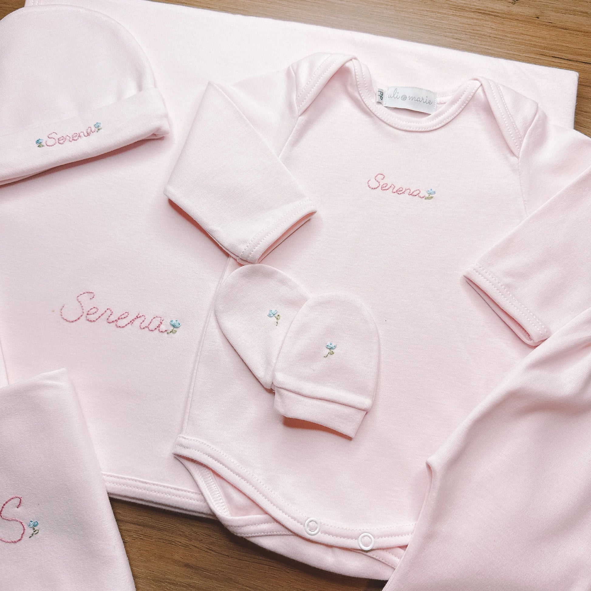 Conjunto rosa bebê com body, calça e gorro; bordado Serena