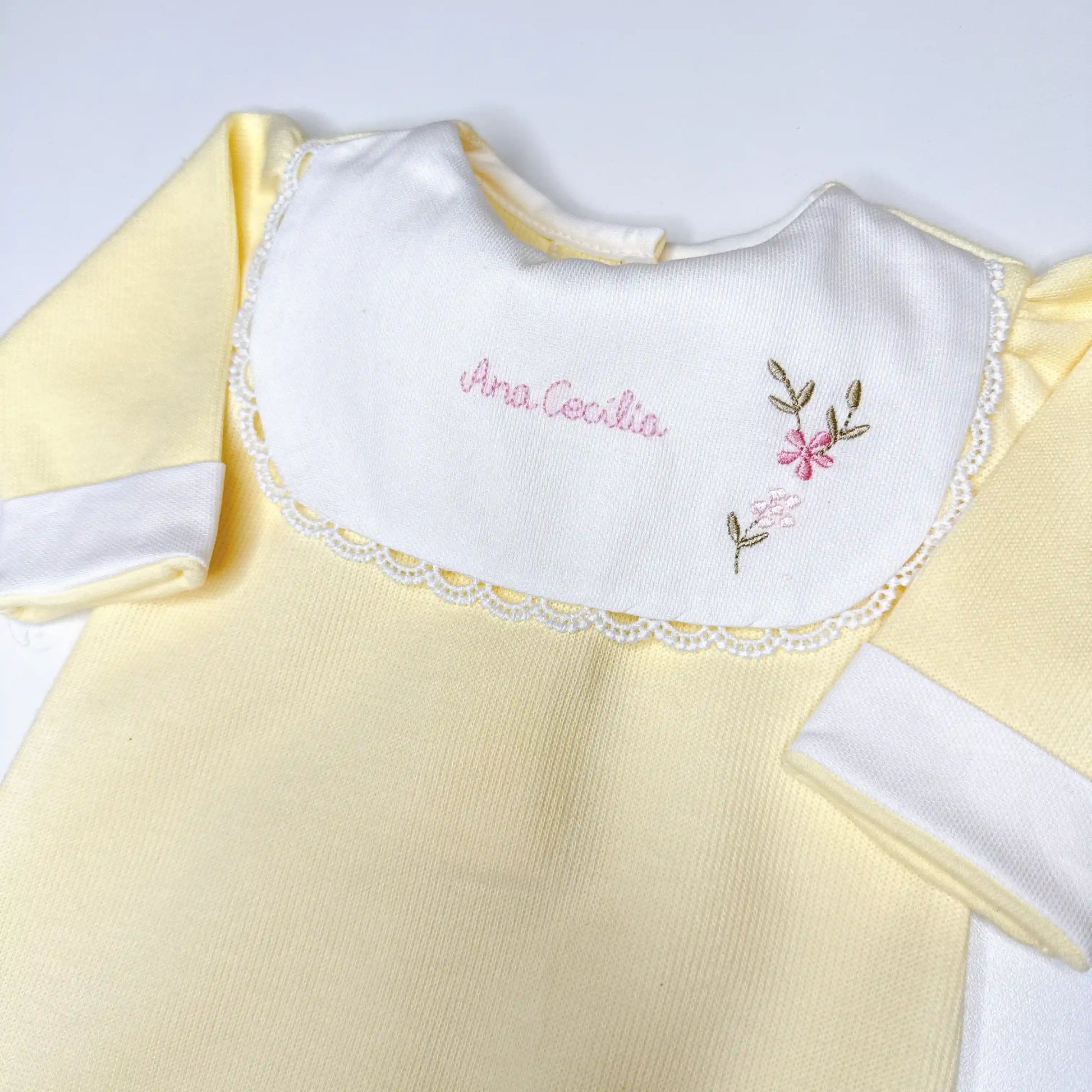 Macacão amarelo claro com gola branca e bordado manual feito à mão com nome e flores delicadas