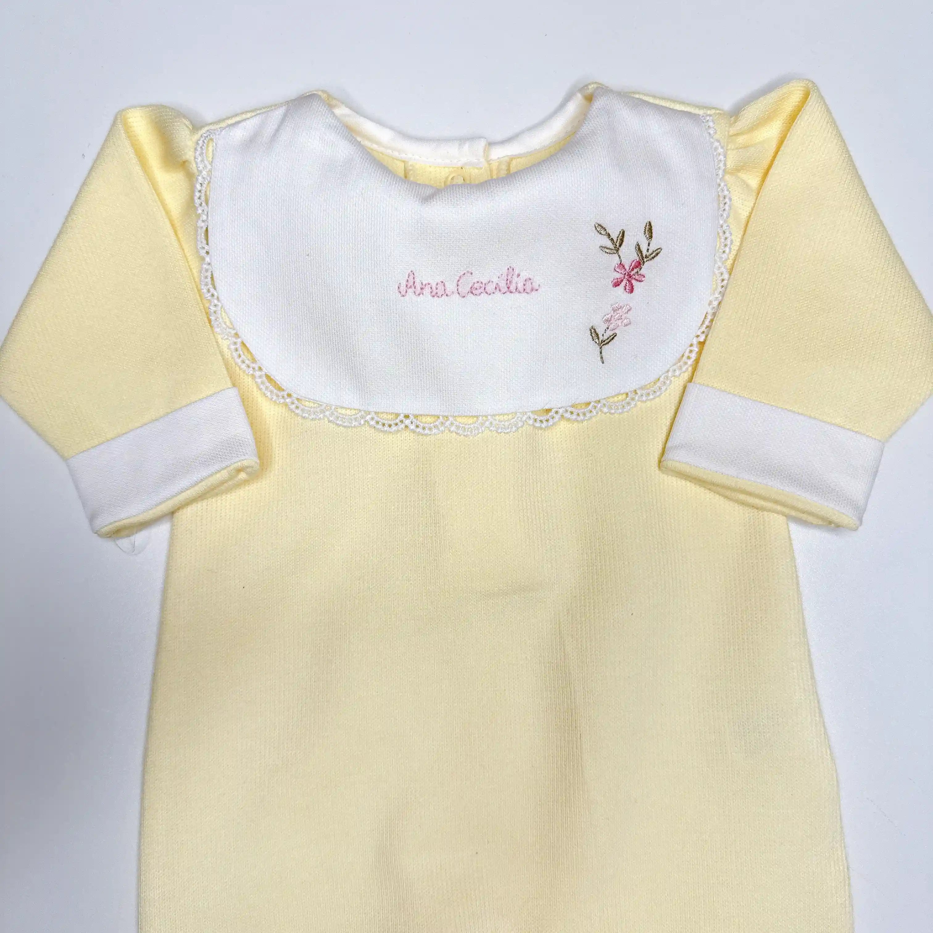 Macacão amarelo claro com gola branca e bordado manual feito à mão com nome e flores delicadas