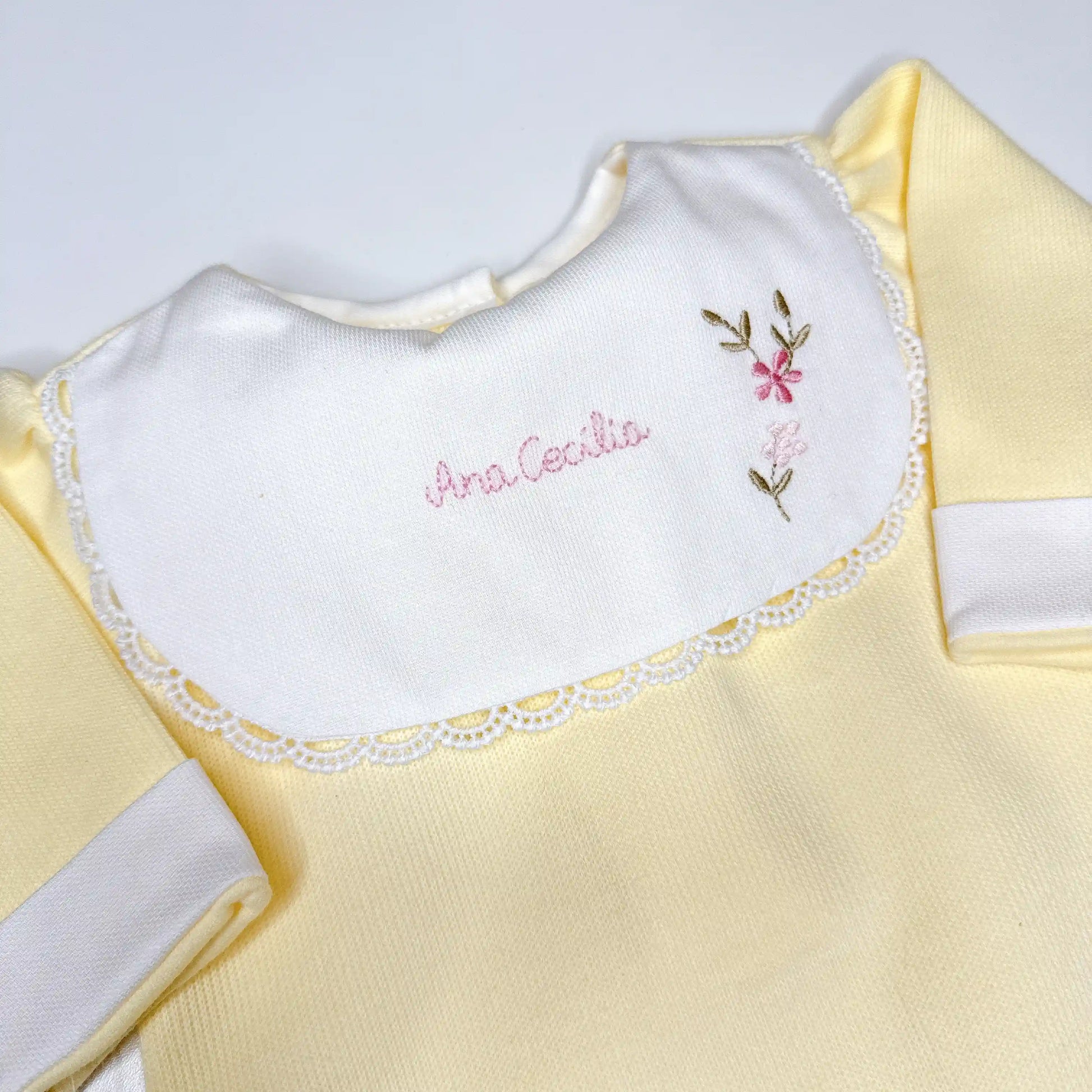 Macacão amarelo claro com gola branca e bordado manual feito à mão com nome e flores delicadas