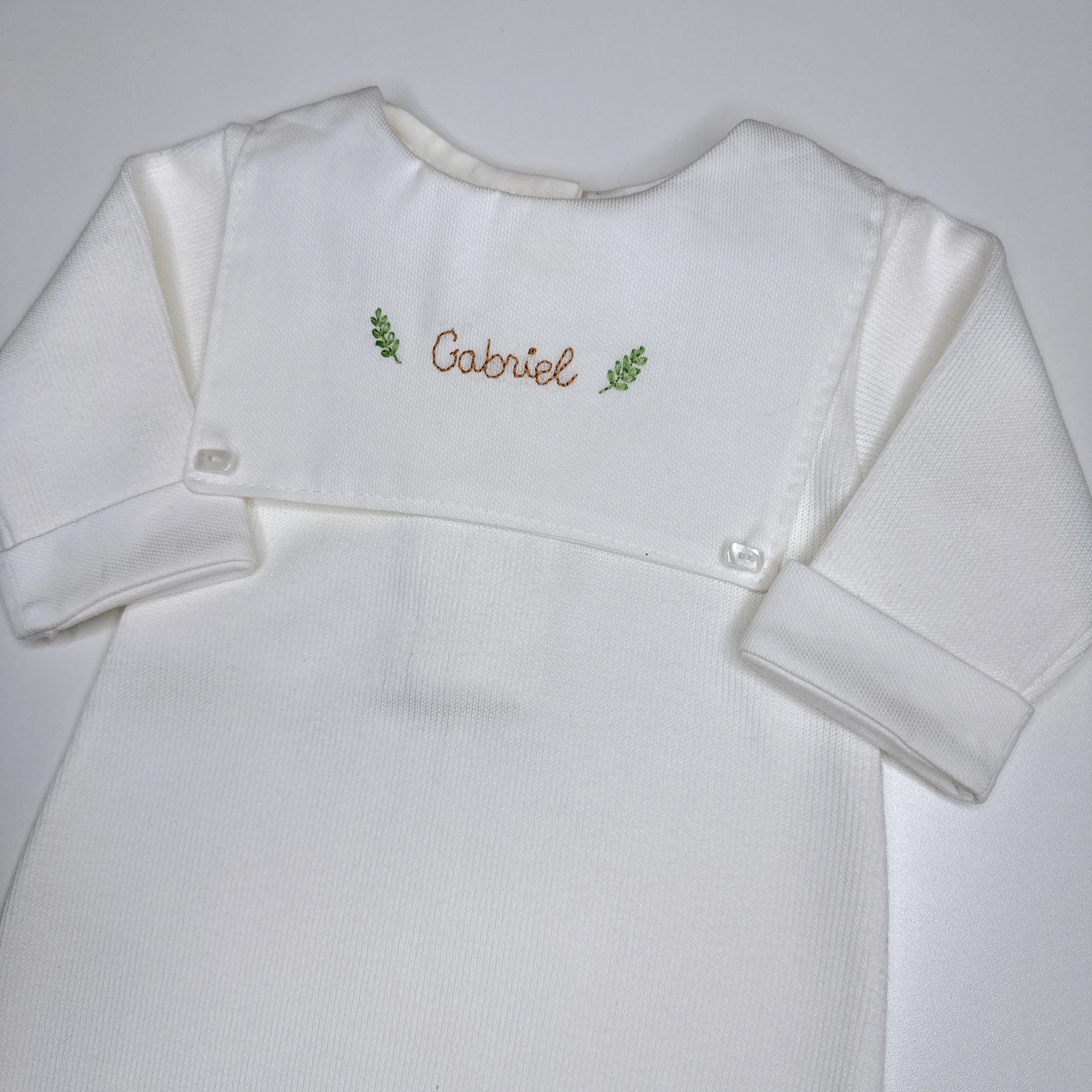Macacão Luiz personalizado branco com pala frontal e nome Gabriel bordado em marrom com ramos verdes