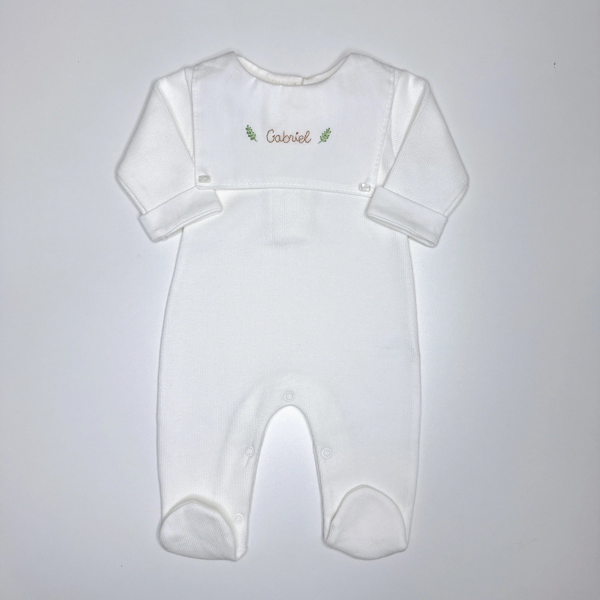 Macacão Luiz personalizado branco com pala frontal e nome Gabriel bordado em marrom com ramos verdes
