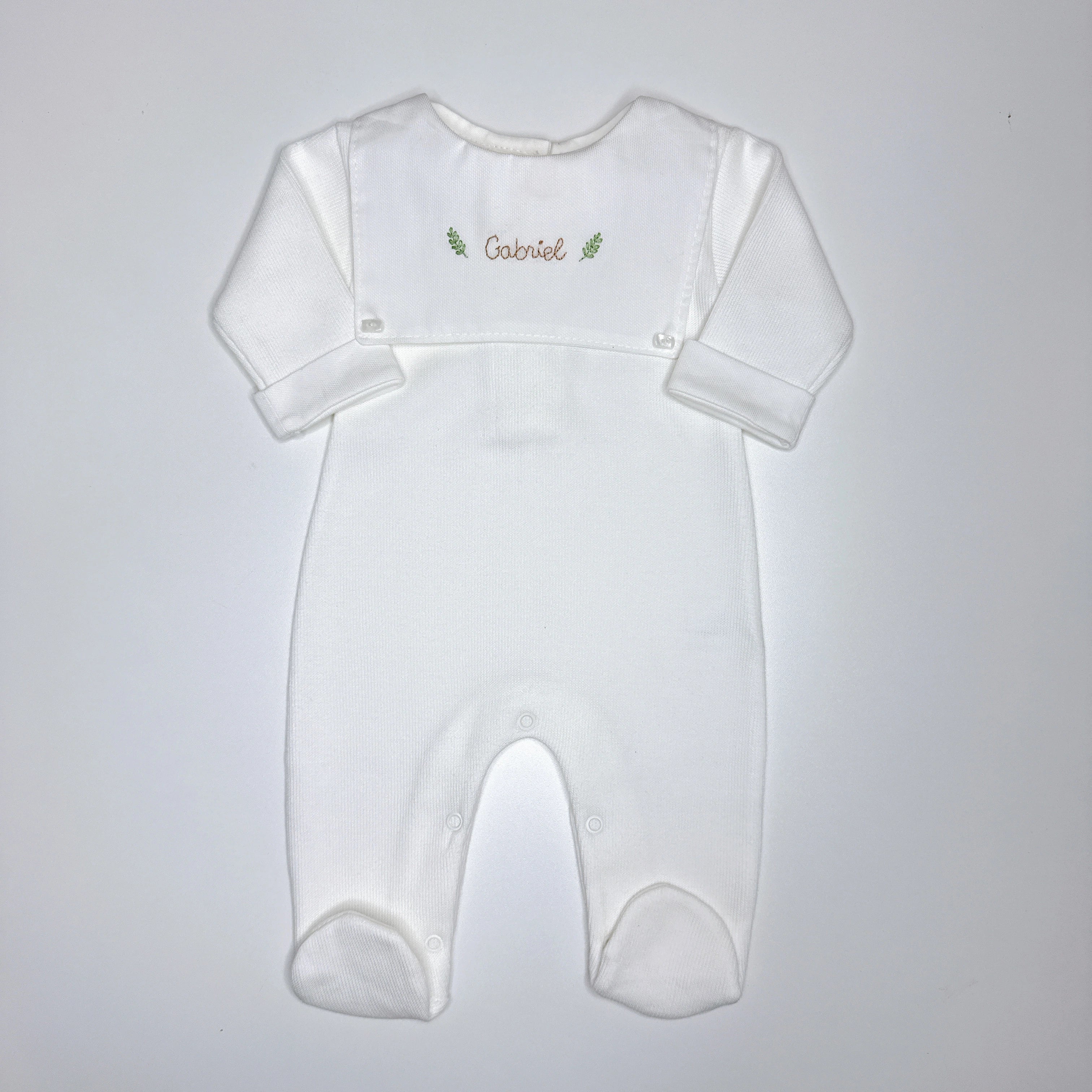 Macacão Luiz personalizado branco com pala frontal e nome Gabriel bordado em marrom com ramos verdes