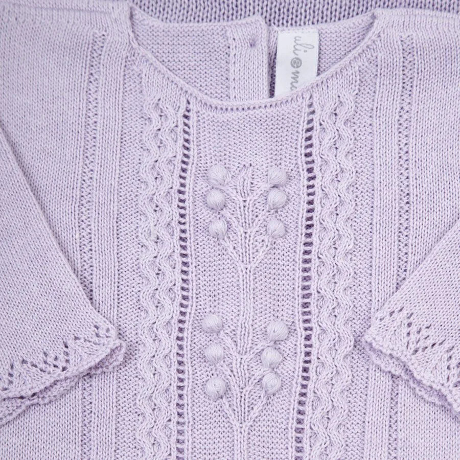 macacão broto lilás em tricô com ponto rendado e detalhe floral central delicado na parte frontal