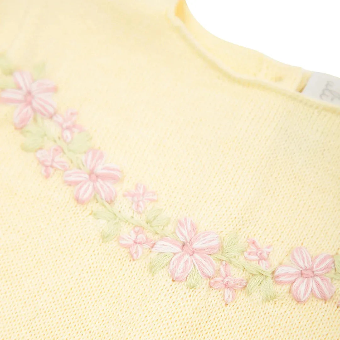 macacão charlotte amarelo bebê com body interno e gola bordada com flores rosas e folhas verdes na altura do ombro