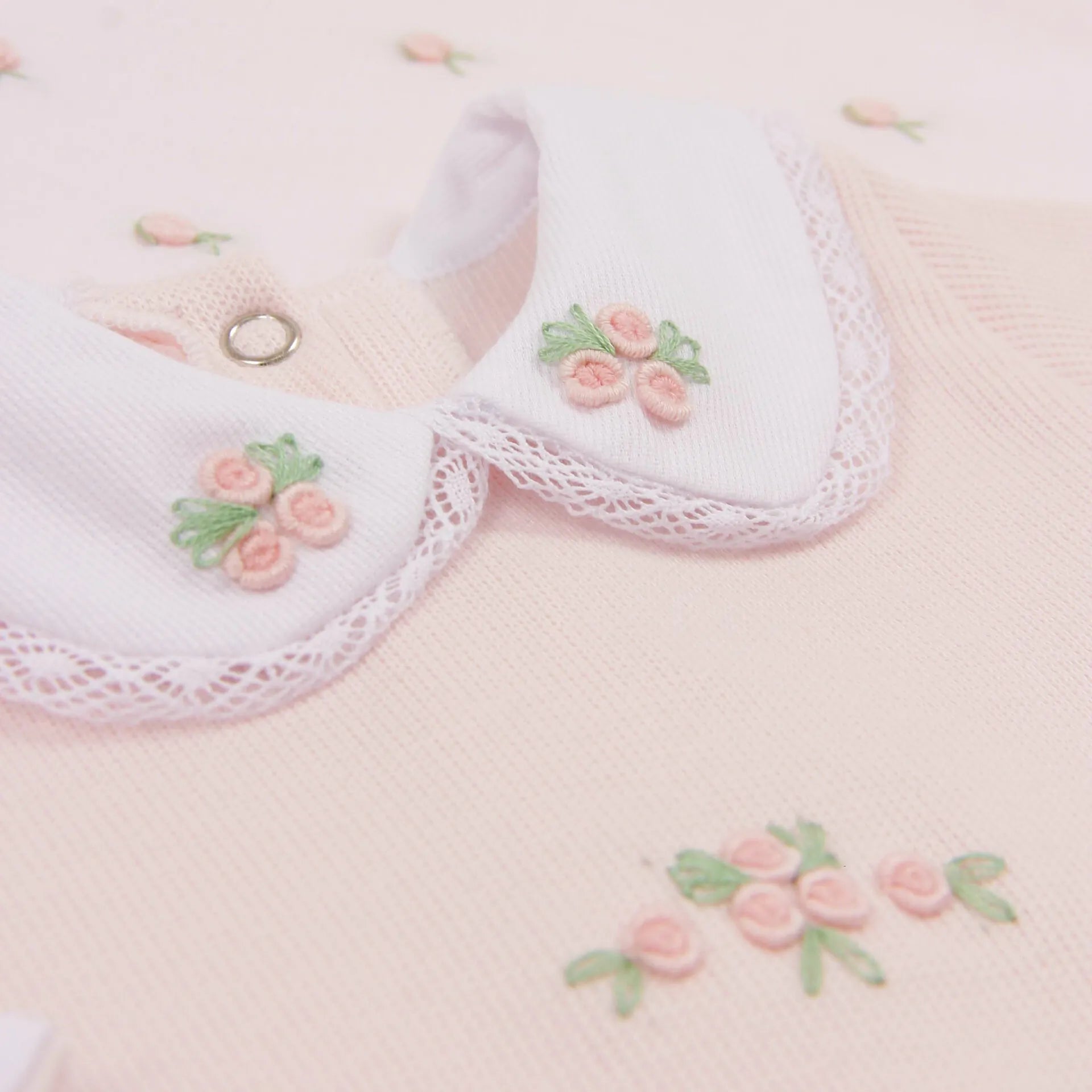 macacão elisa rosa bebê com foco no bordado floral triplo da gola peter pan, com detalhes em rosa e verde em tricot