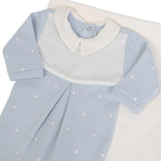 macacão heitor azul bebê com gola branca e bordado de poás brancos, detalhe de pala canelada e pregas frontais 