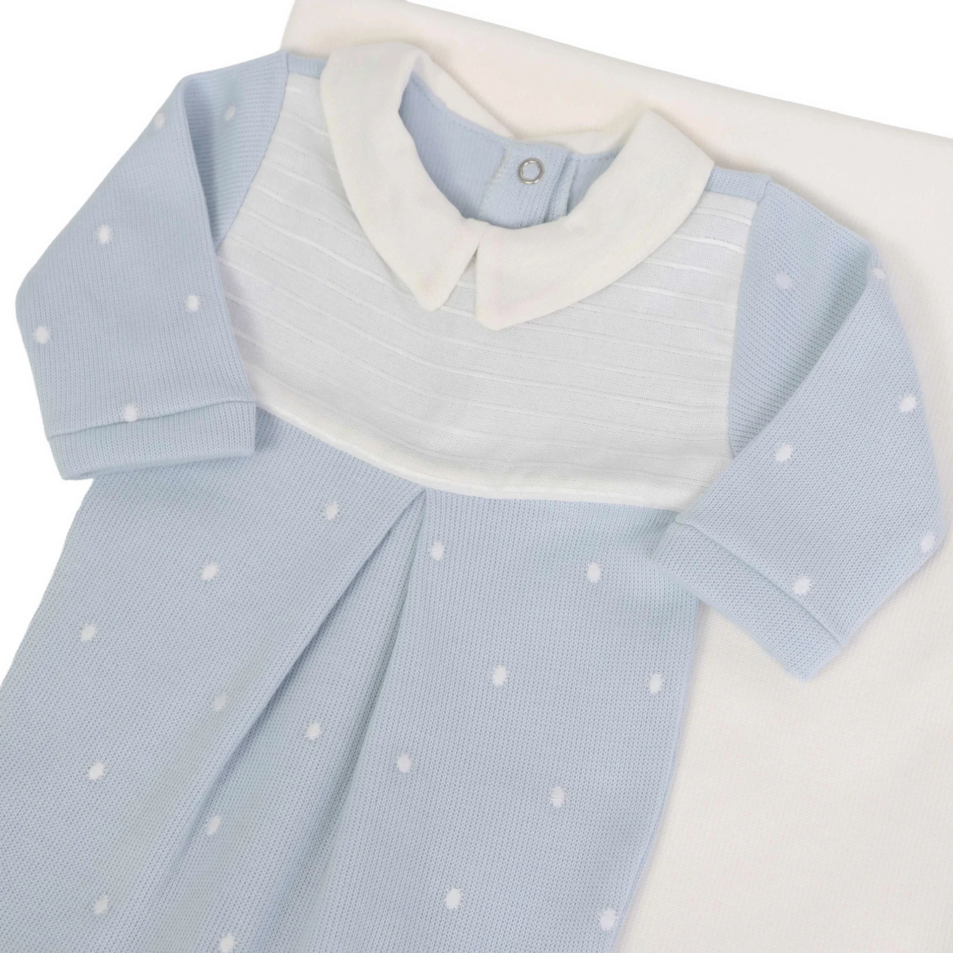 macacão heitor azul bebê com gola branca e bordado de poás brancos, detalhe de pala canelada e pregas frontais 