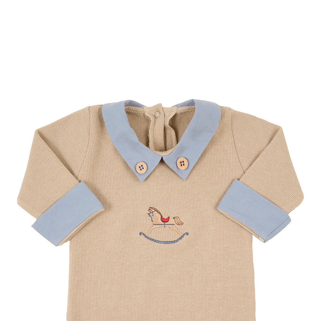 macacão horse em algodão, cor bege, com gola azul bebê e botões de madeira, destacando o bordado de cavalo de balanço
