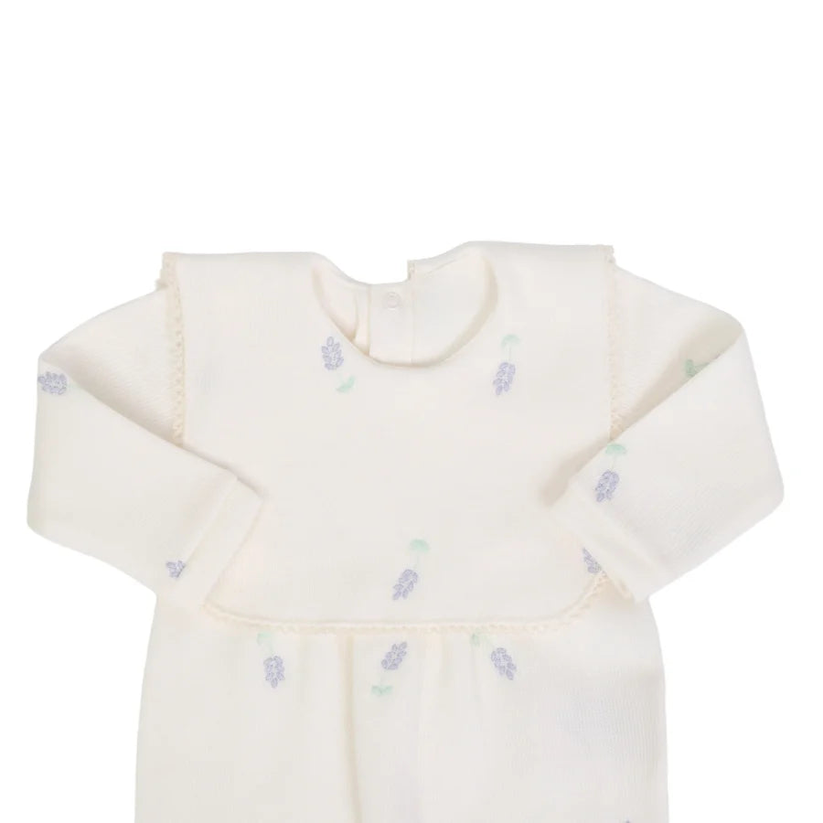 detalhe do macacão hortência off-white mostrando a pala fixa e os bordados de flores lilás com folhas verdes