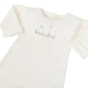 detalhe do macacão jardim off-white mostrando a pala bordada com flores e borboletas em tons pastel