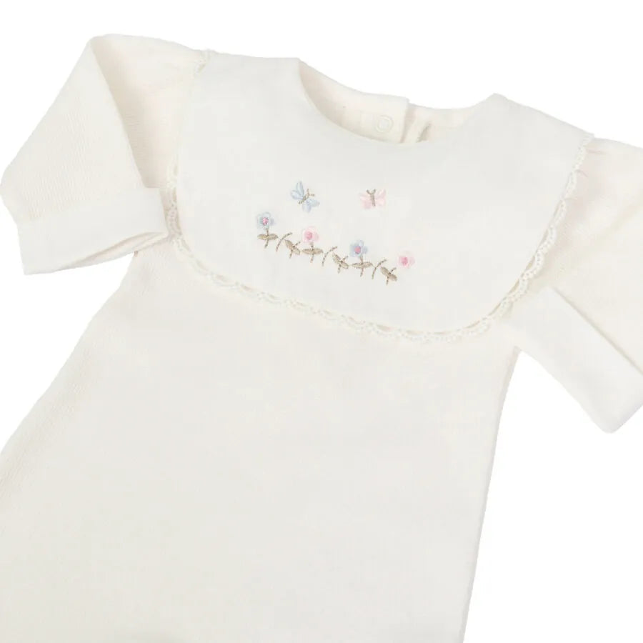 detalhe do macacão jardim off-white mostrando a pala bordada com flores e borboletas em tons pastel