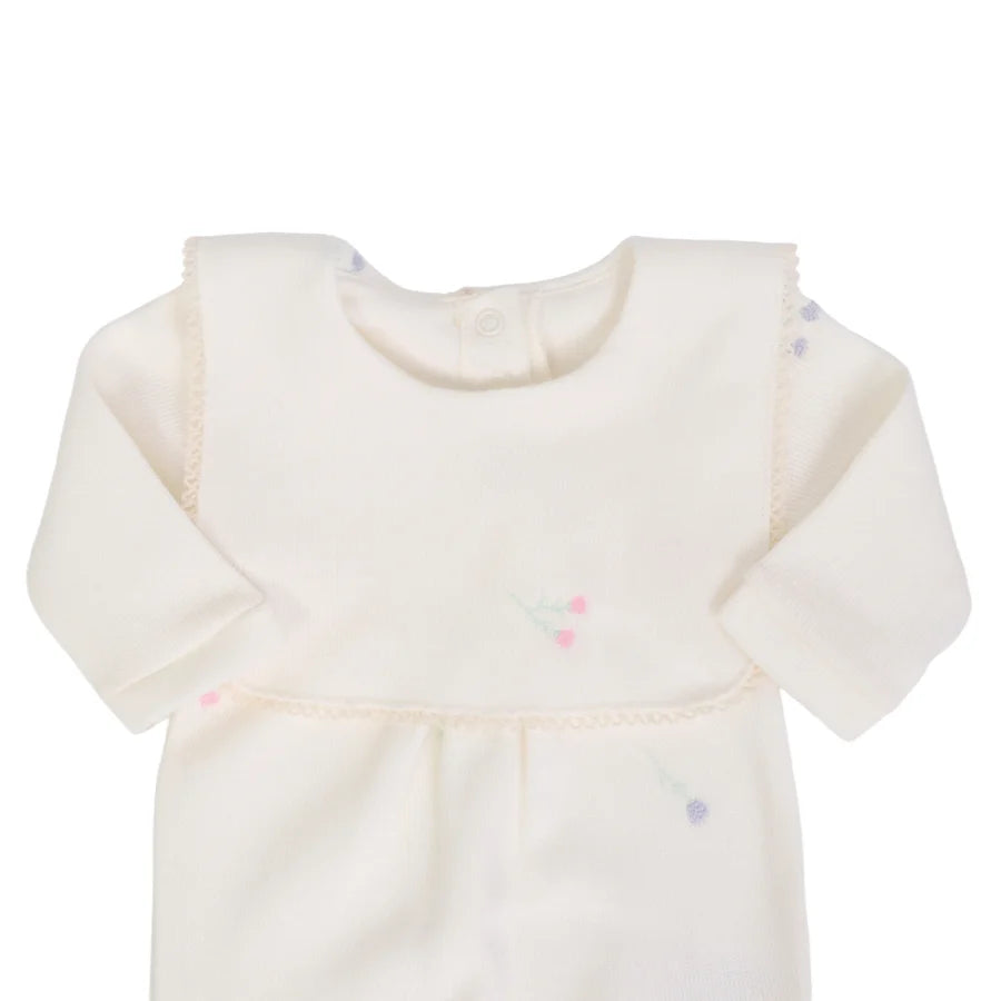 detalhe do macacão primavera off-white destacando a pala fixa e os bordados sutis de flores coloridas