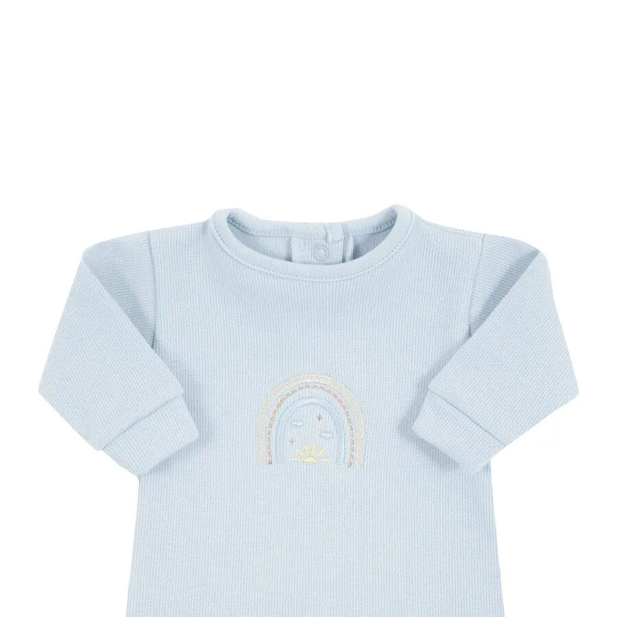 macacão rainbow azul bebê liso com pezinho fechado e bordado sutil de arco-íris no centro do peito