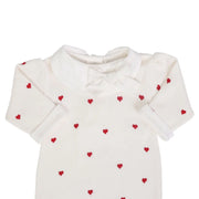 detalhe do macacão rita off-white mostrando a gola peter pan e o laço no decote com bordados de corações vermelhos