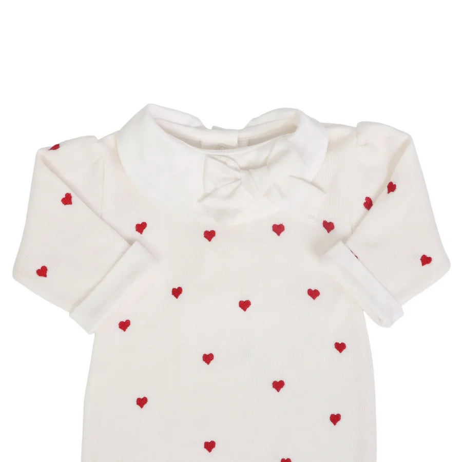 detalhe do macacão rita off-white mostrando a gola peter pan e o laço no decote com bordados de corações vermelhos