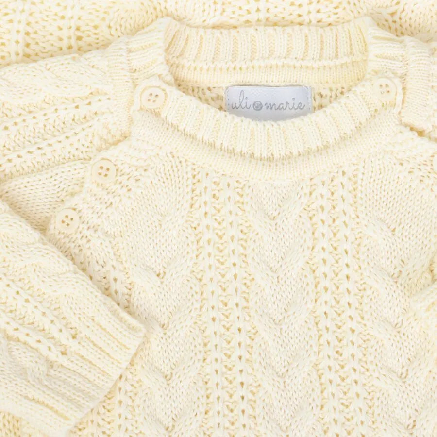 macacão sorrento amarelo bebê em tricô com tranças frontais e detalhes texturizados em tom suave de amarelo