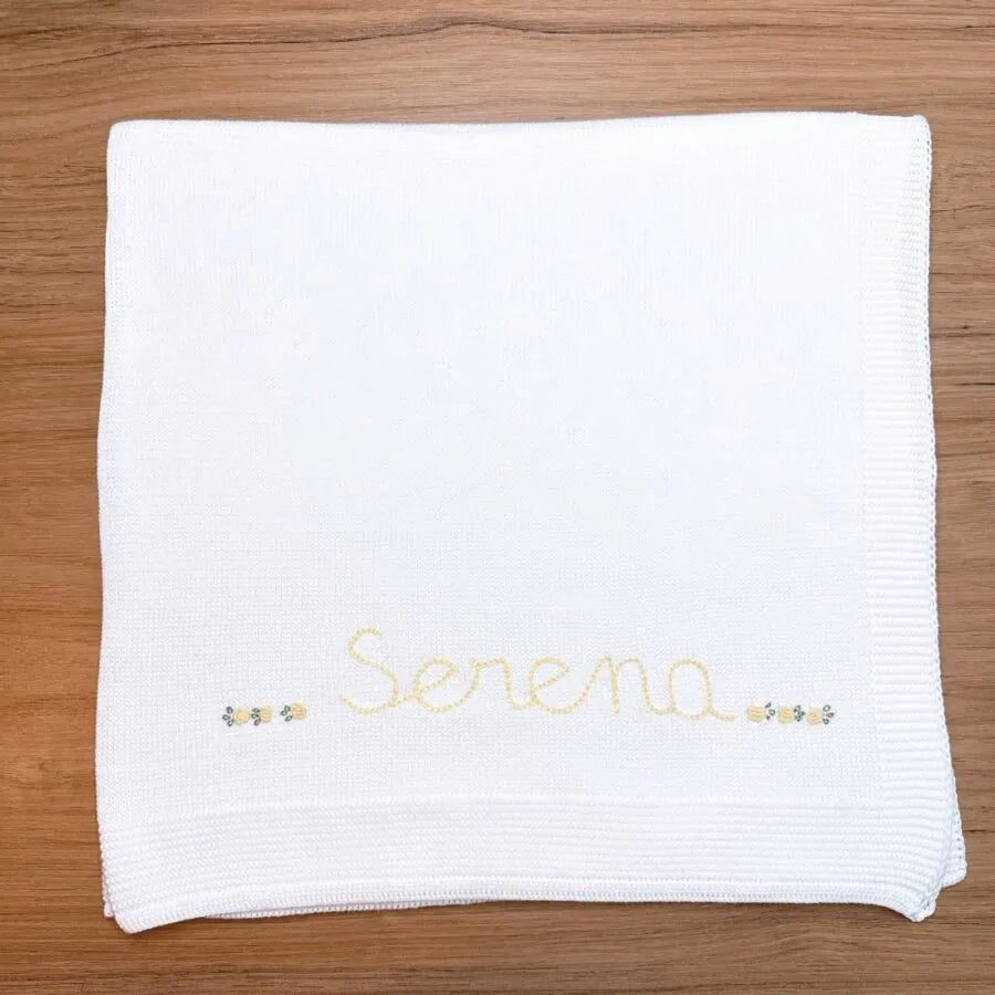 manta básica personalizada, confeccionada em tricô macio com nome bordado e delicados detalhes florais, perfeita para aconchegar o bebê com carinho e exclusividade