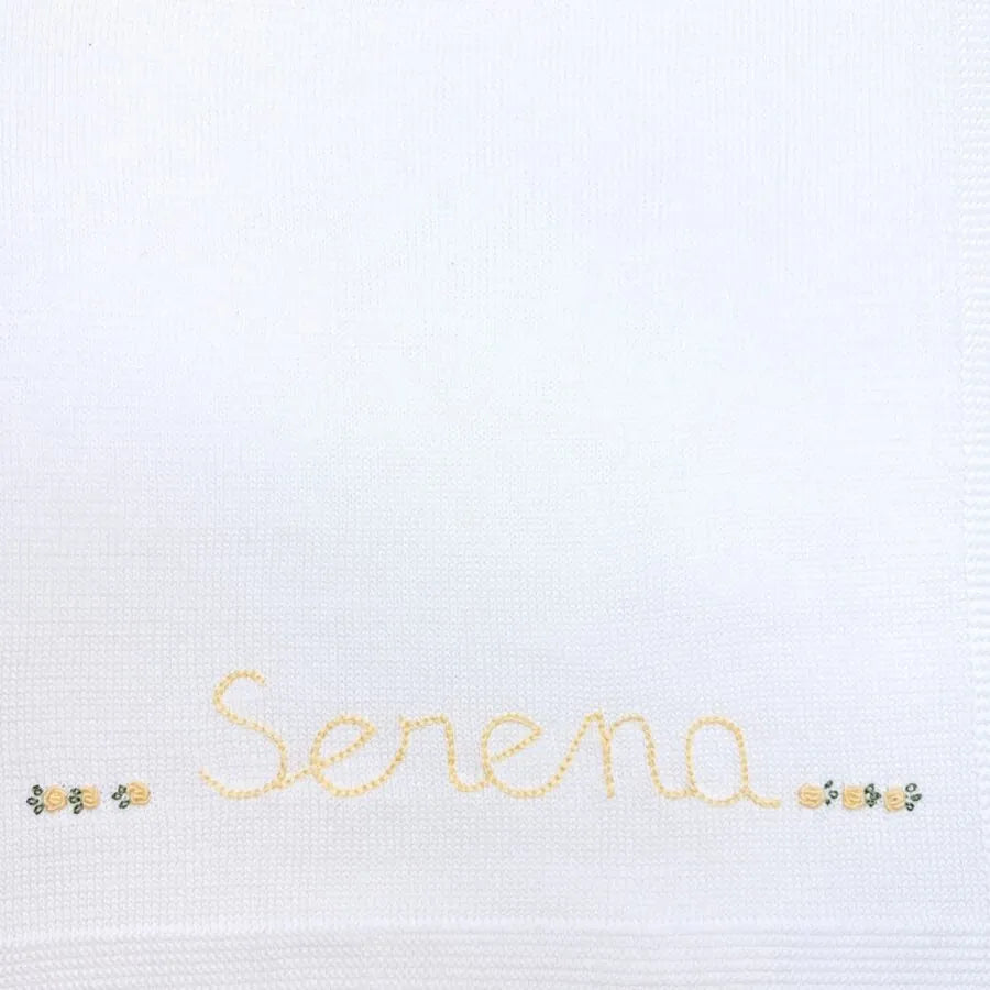 manta básica personalizada, confeccionada em tricô macio com nome bordado e delicados detalhes florais, perfeita para aconchegar o bebê com carinho e exclusividade